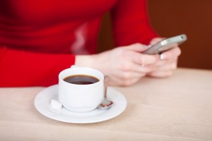 woman writing sms and drinking coffee