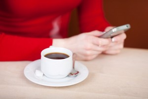 woman writing sms and drinking coffee